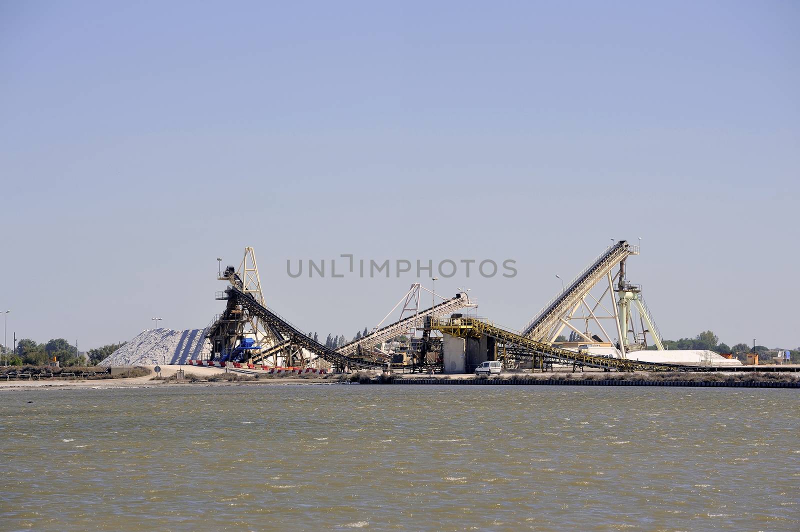 Site operating sea salt saline Aigues-Mortes with big machines and trucks working for the salt storage