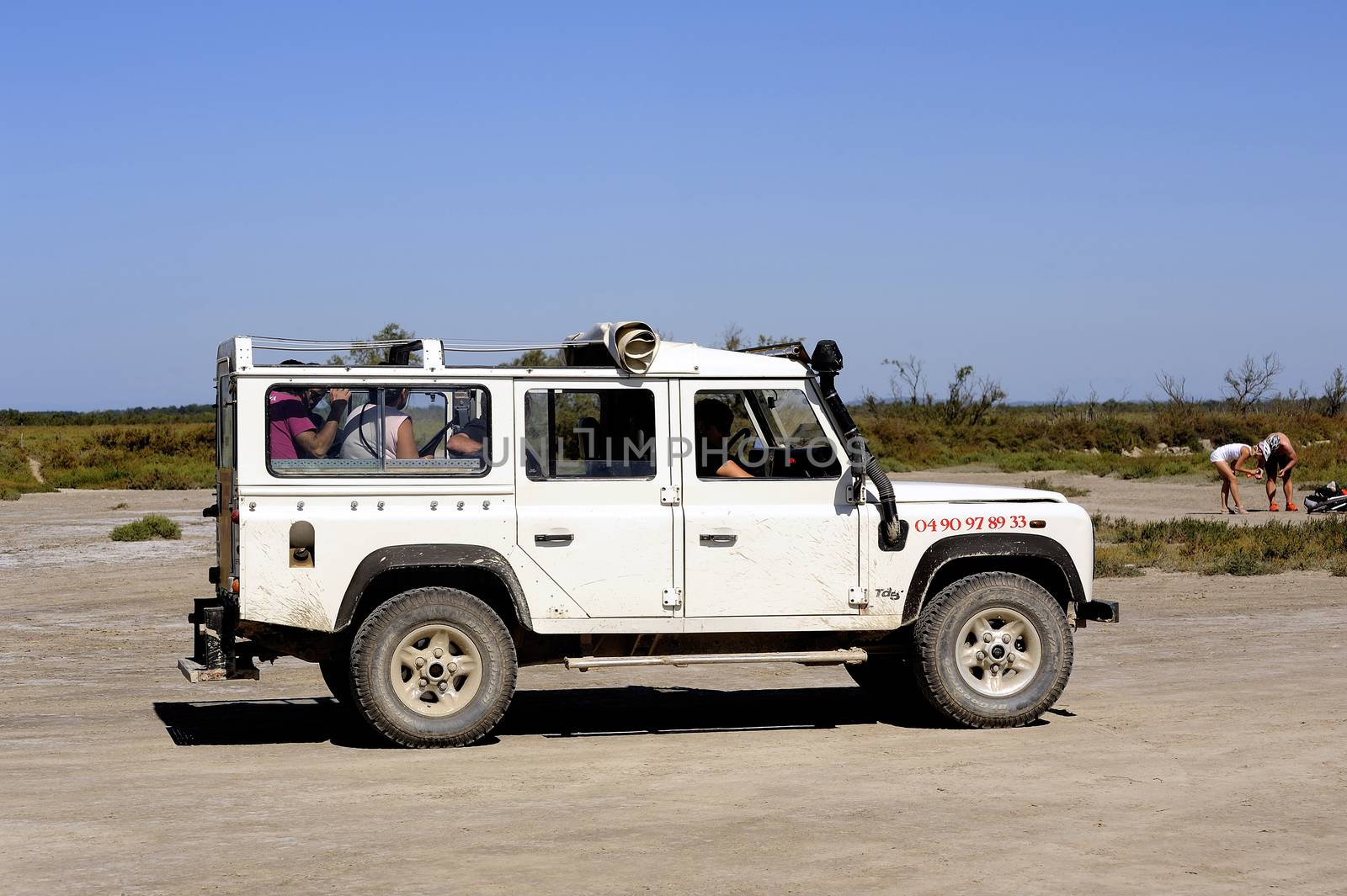 Tourists visiting the Camargue 4x4 with a guide to explain the area and wildlife such as flamingos.