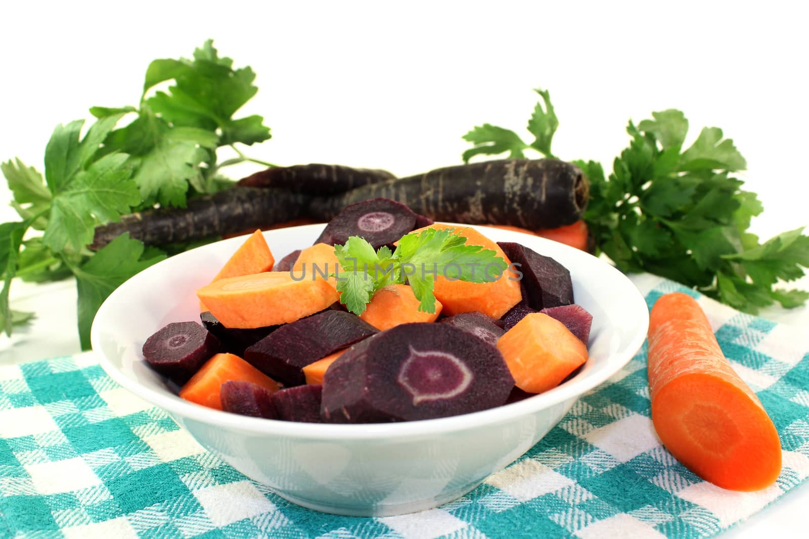 cut carrots in a white bowl against white background