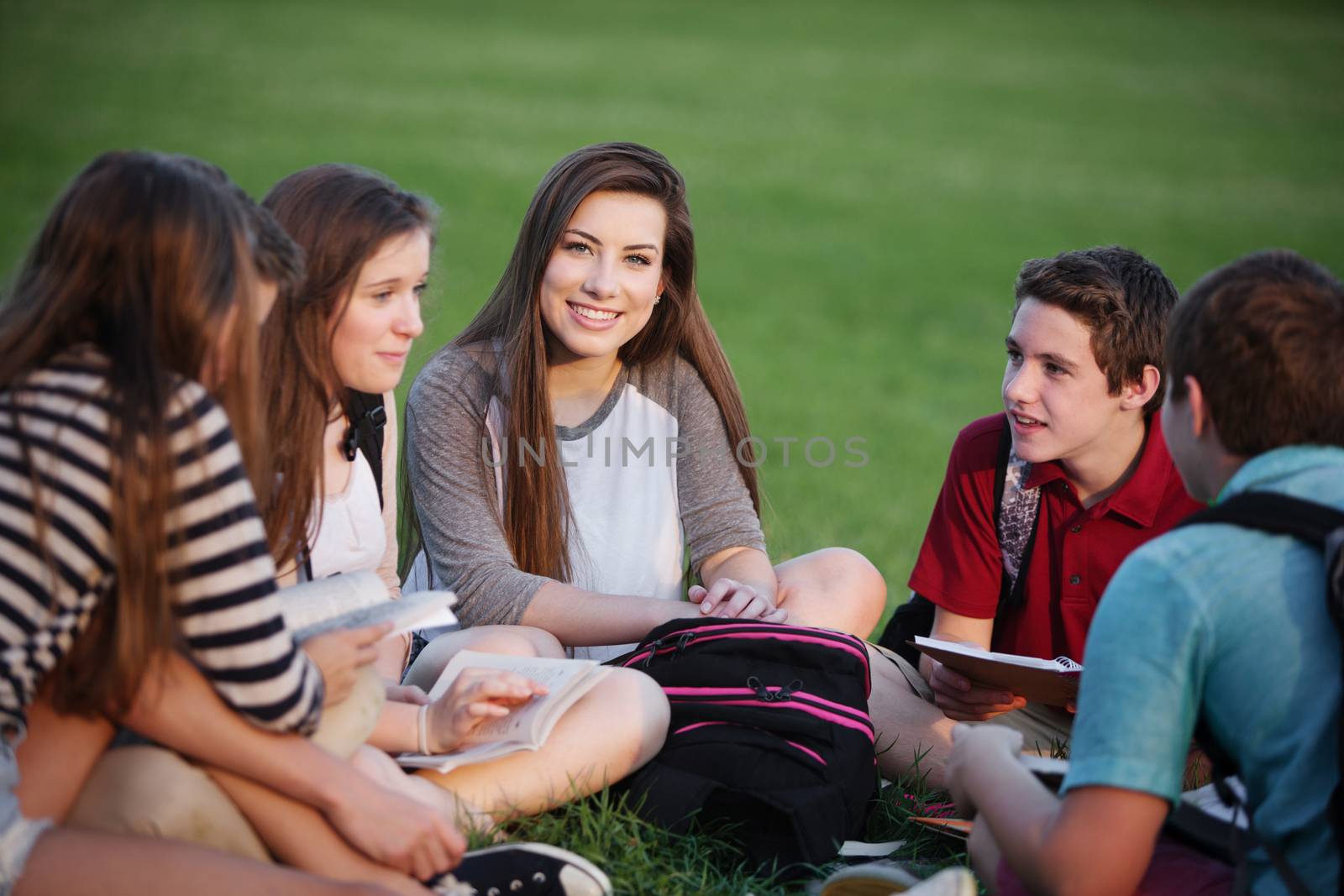 Happy young female student talking with friends