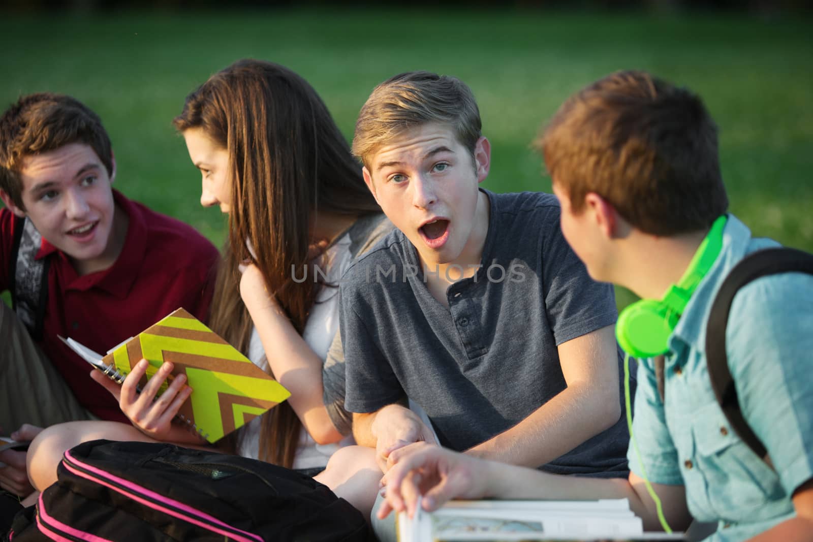 Surprised young student with group of friends outdoors