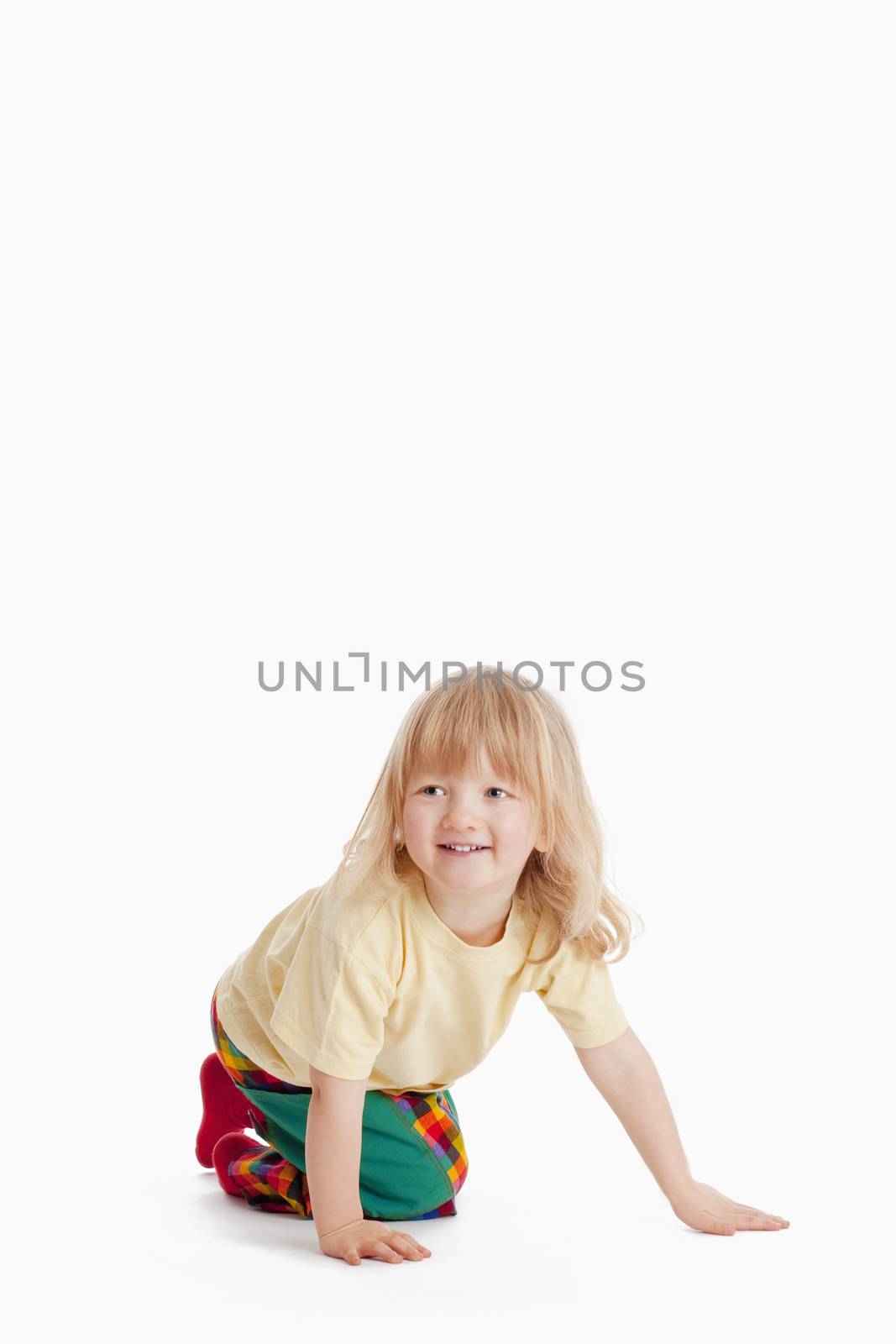 boy with long blond hair on the floor smiling isolated on white