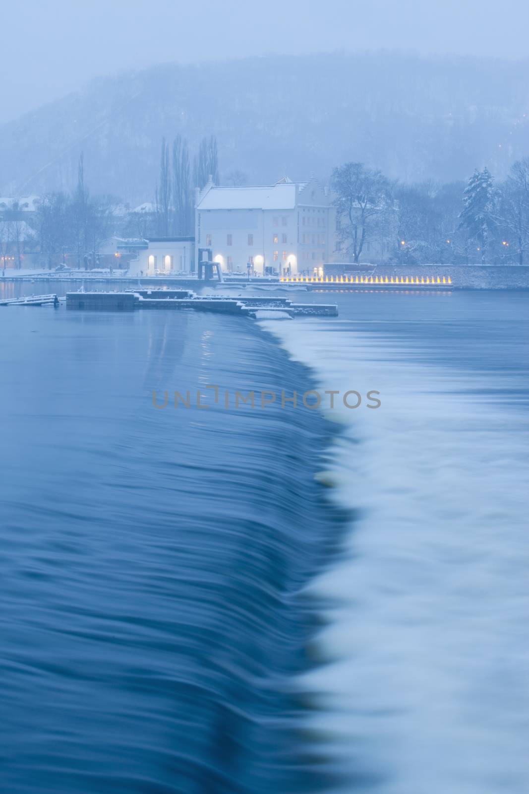 prague in winter - dam at vltava river and kampa museum at dusk