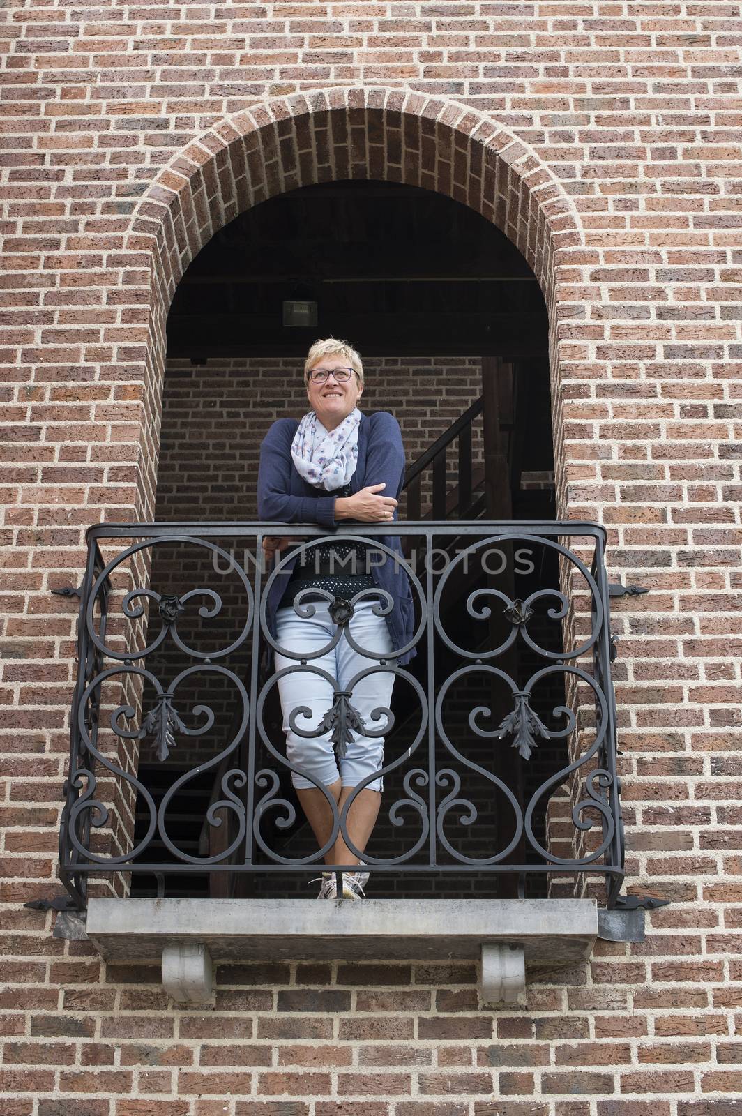woman looking forward standing on balcony of italian house