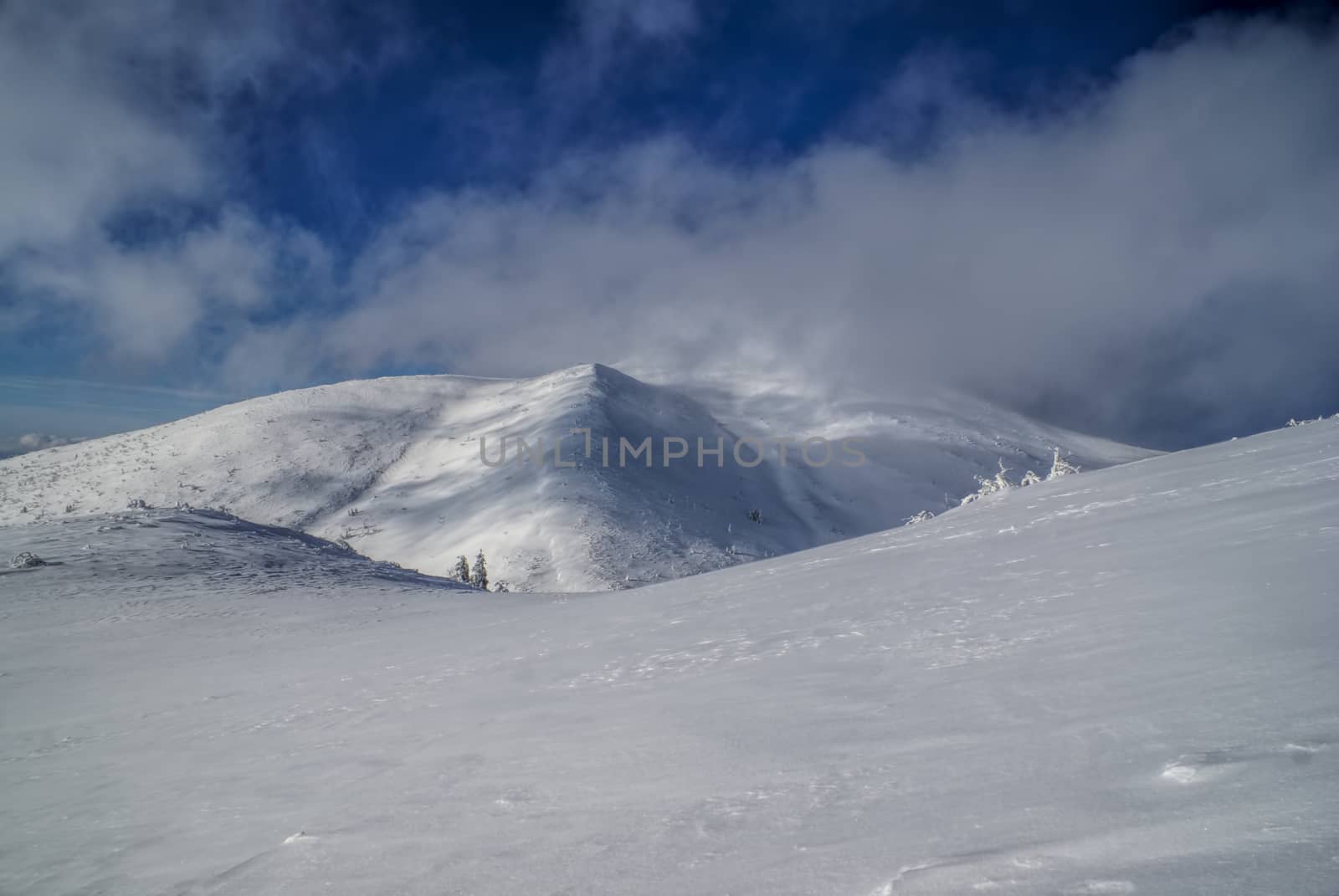 Picturesque view of clouds passing over snowy slopes                  