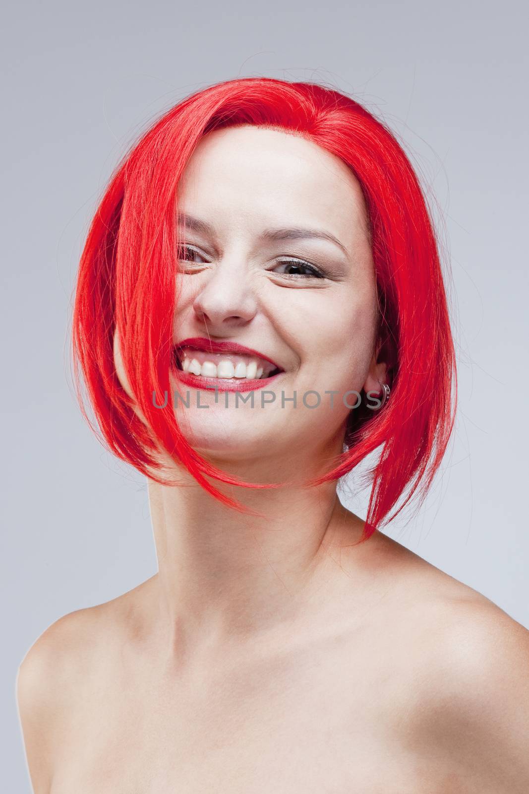 Portrait of a Young Woman in Red Wig - Isolated on Gray