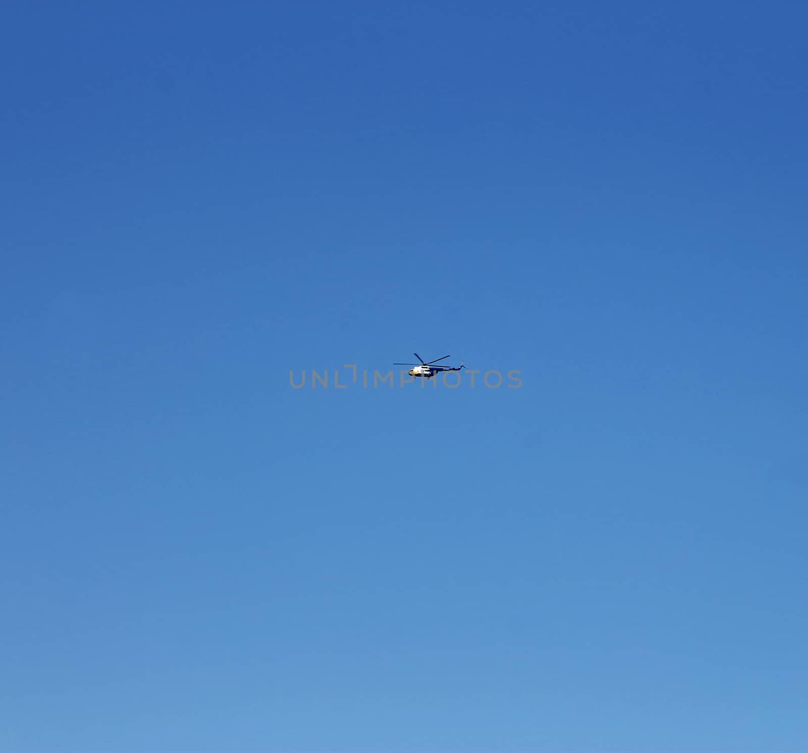 Helicopter flightning in blue sky with clouds