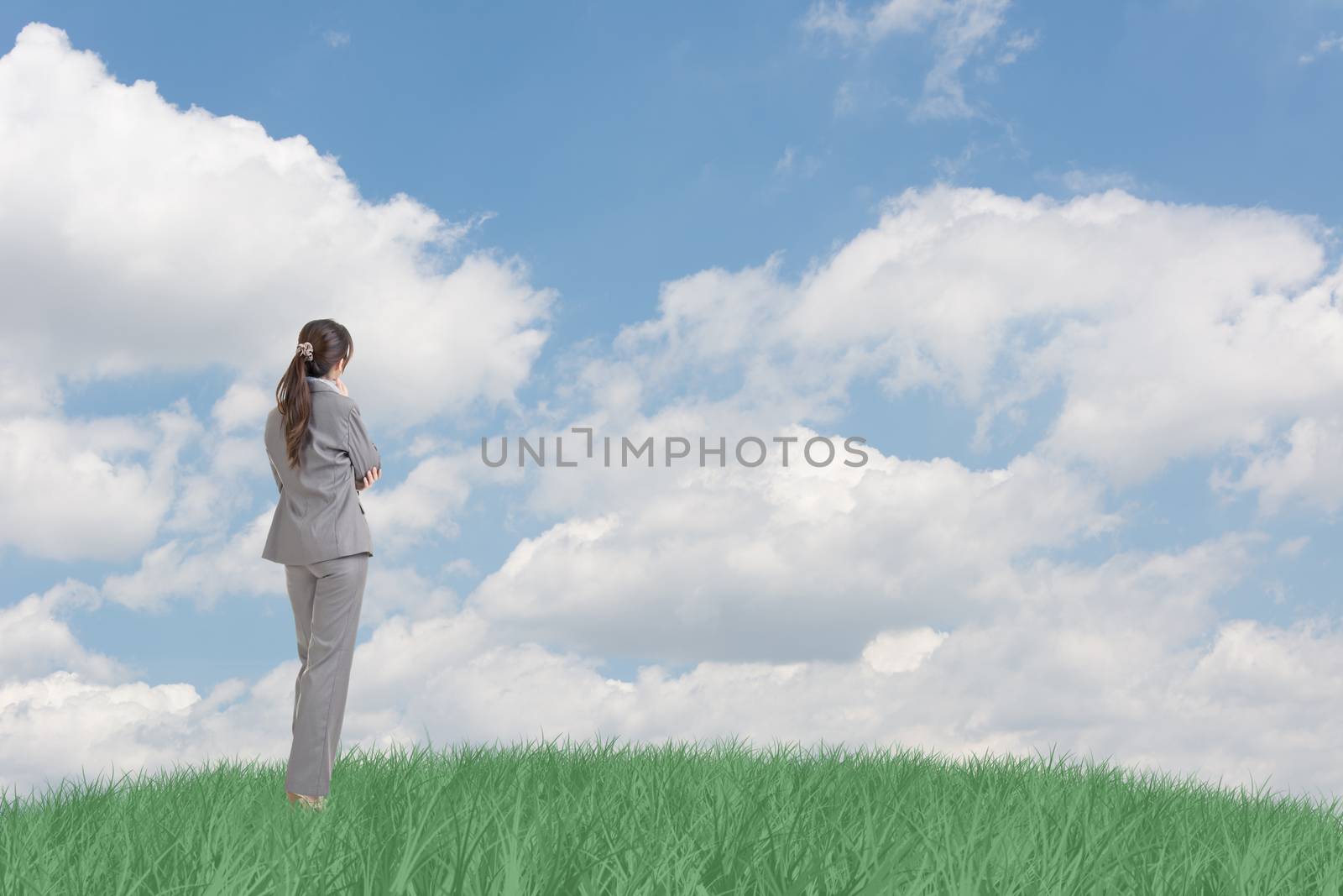 Asian business woman standing on grassland and thinking with copyspace on heaven.