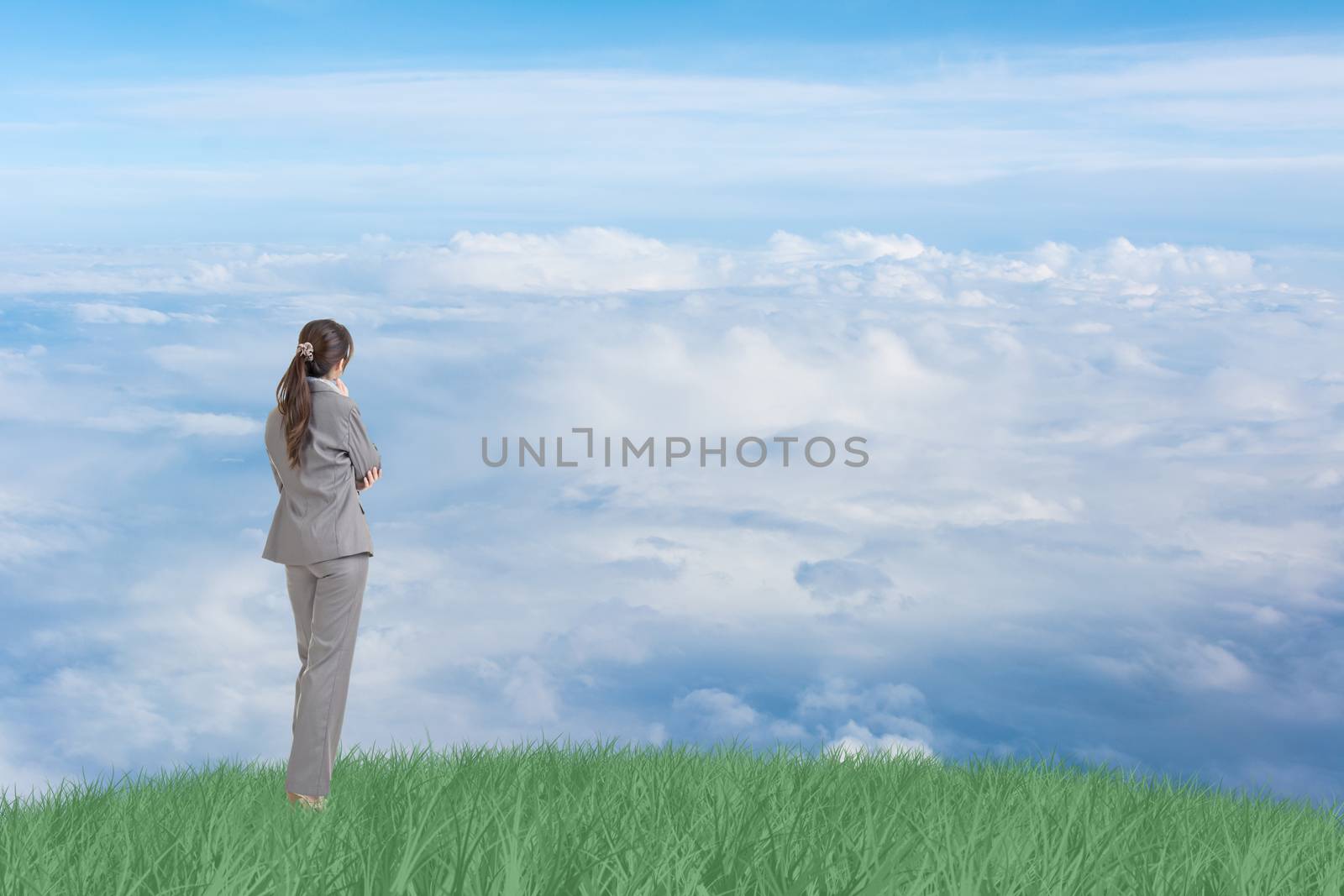 Asian business woman standing on grassland and thinking with copyspace on heaven.