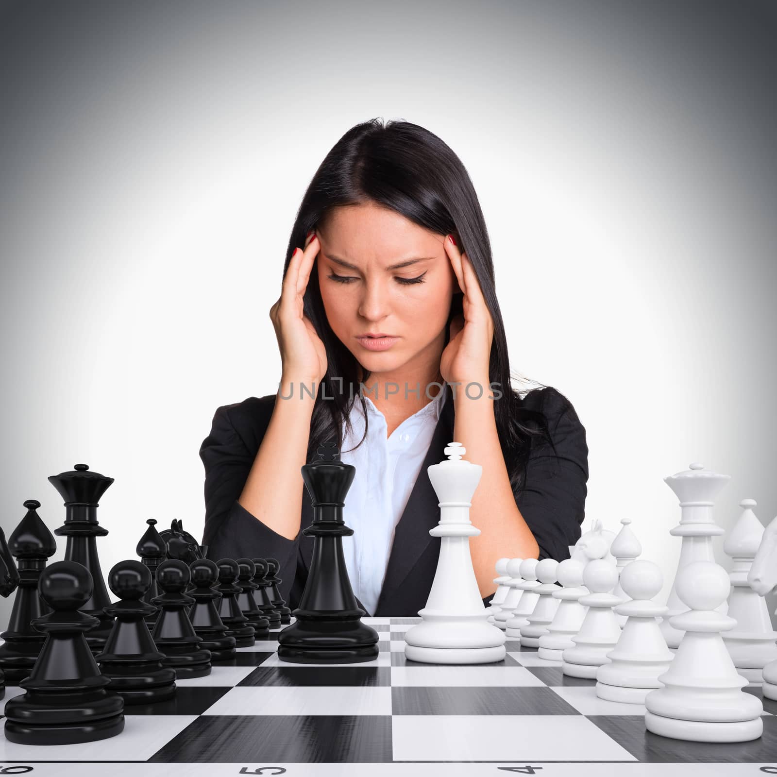 Lost in thought businesswoman looking at chess board with chess. Gray background. Business concept
