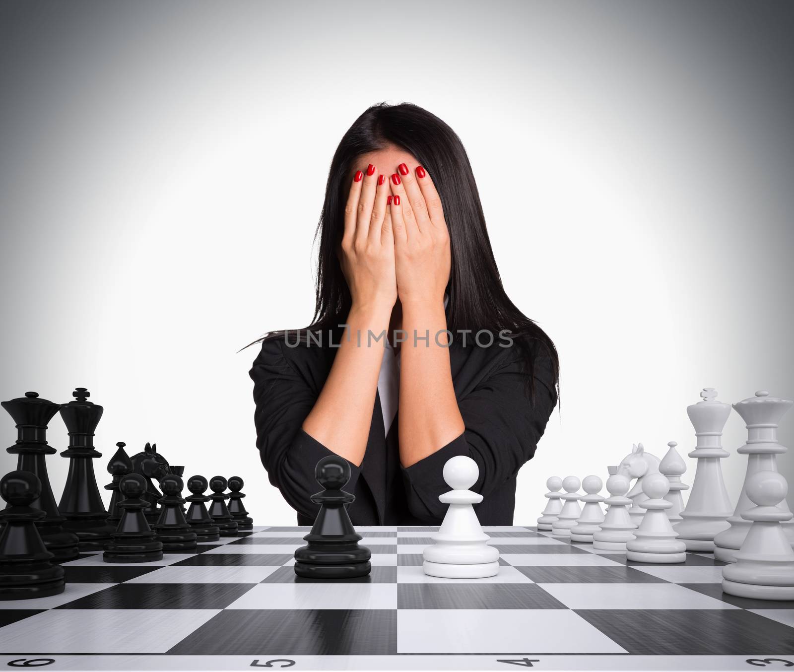 Businesswoman covering her face with hands. Chessboard and chess by cherezoff