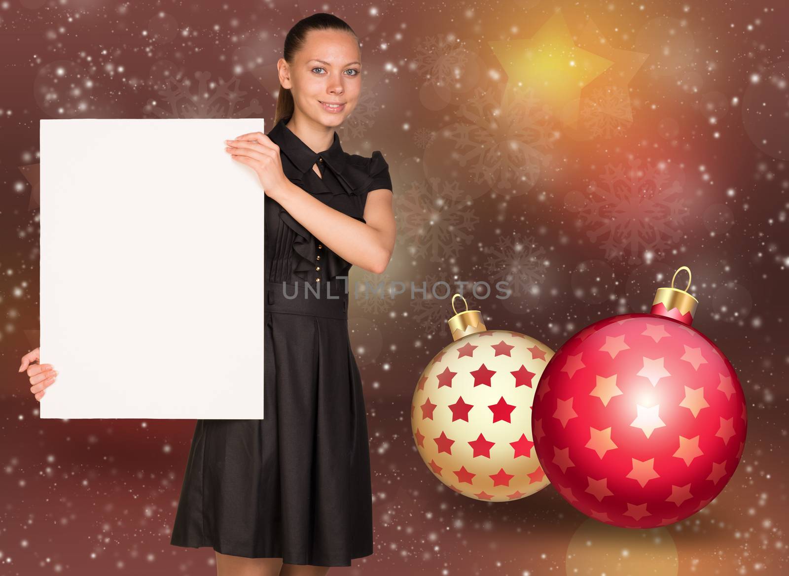 Businesswoman holding empty paper. Christmas tree balls as backdrop