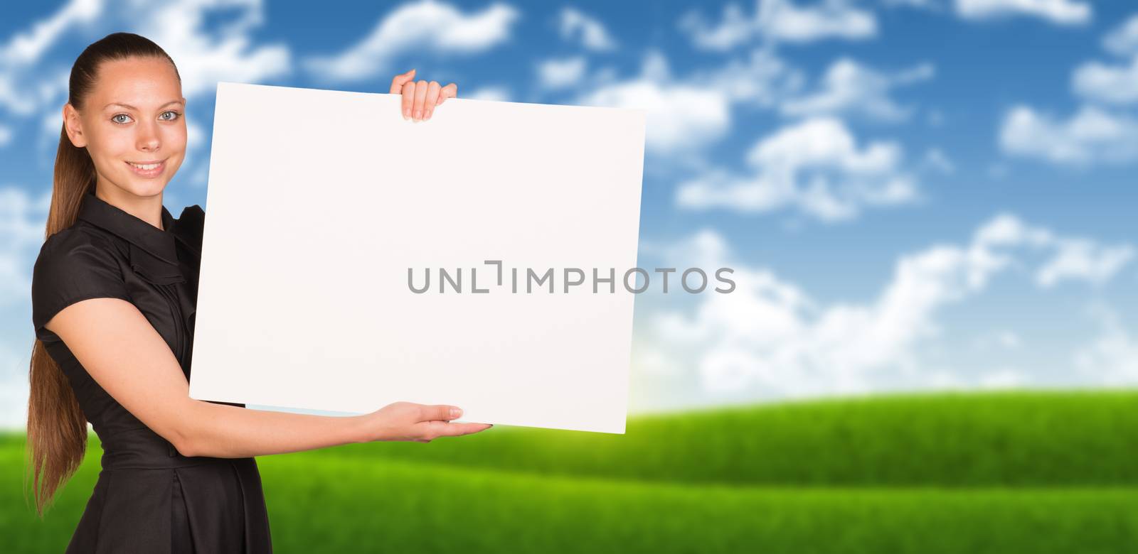 Businesswoman holding empty paper. Blured nature landscape as backdrop