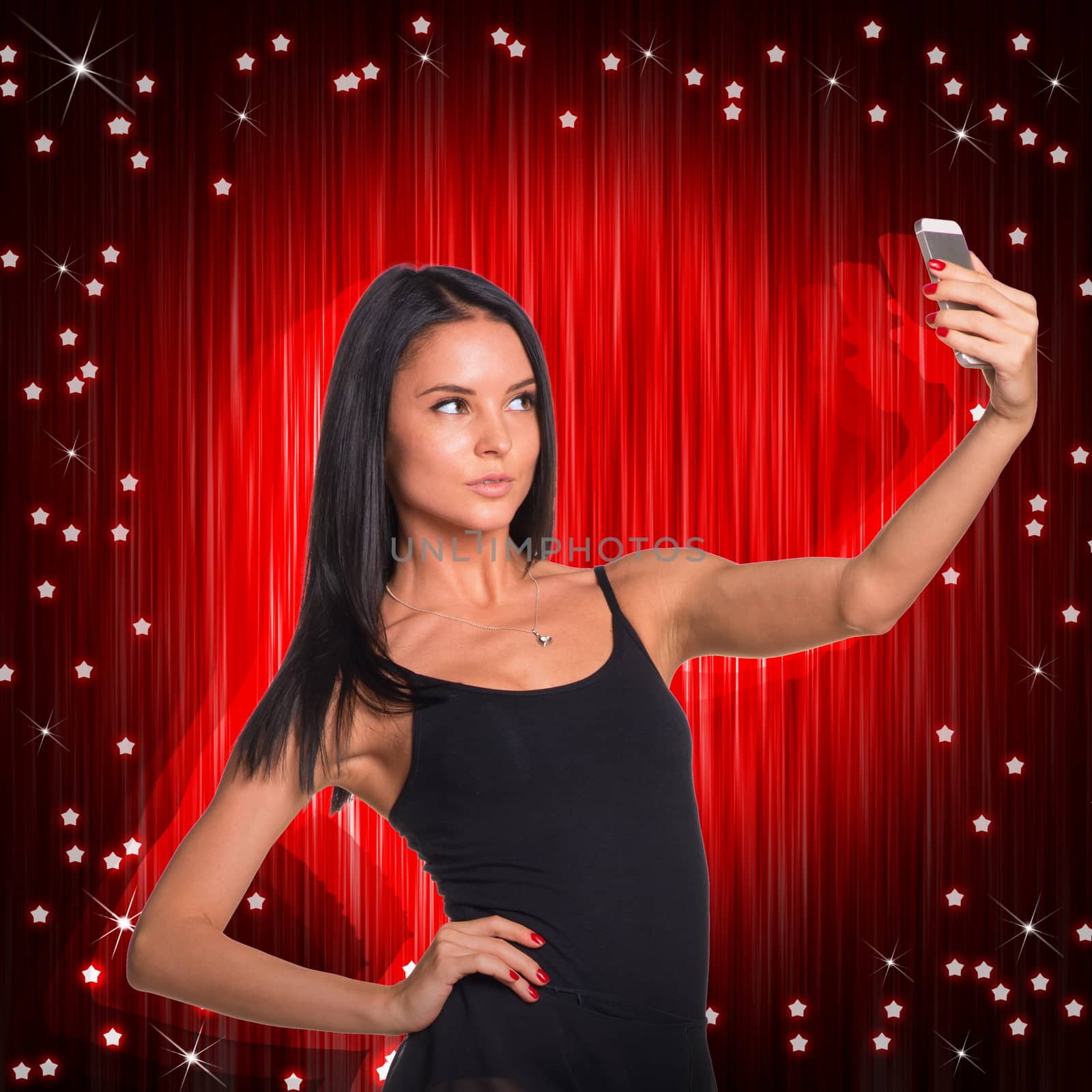 Beautiful dancer makes selfie from your mobile phone. Red curtain as backdrop