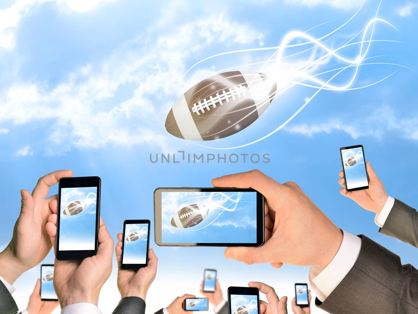 Hands holding smart phones and shoot video as falling American football by cherezoff