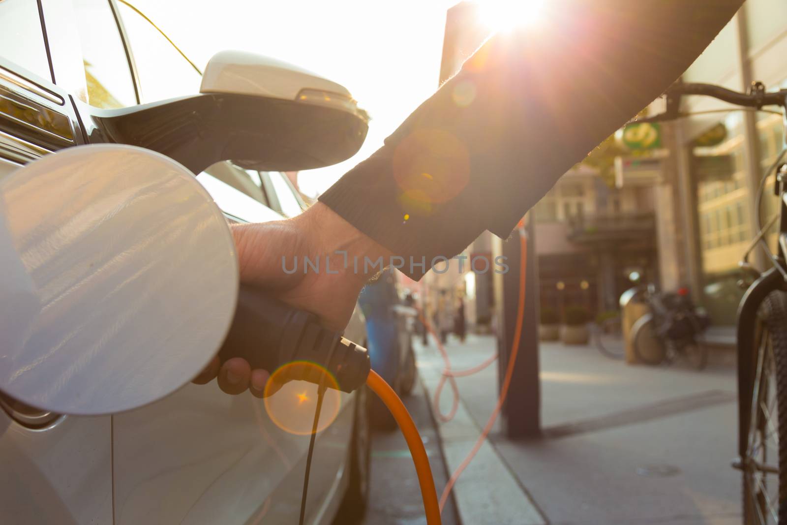 Power supply for electric car charging.  Electric car charging station. Close up of the power supply plugged into an electric car being charged.