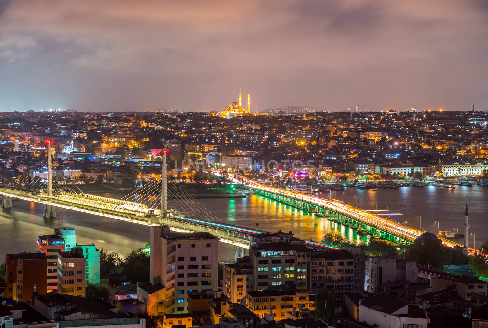 ISTANBUL - SEPTEMBER 17, 2014: City night panorama with New Galata Bridge and Ataturk Bridge on background. Istanbul is visited by more than 11 million people every year.