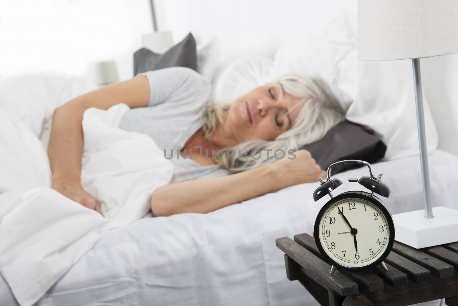 Sleeping woman in front of the alarm clock