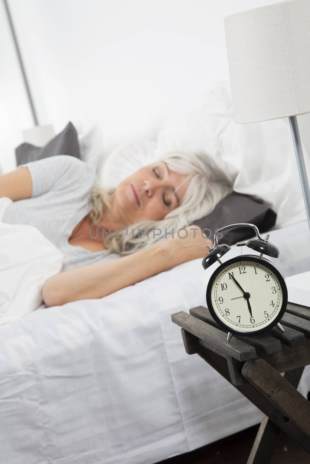 Sleeping woman in front of the alarm clock