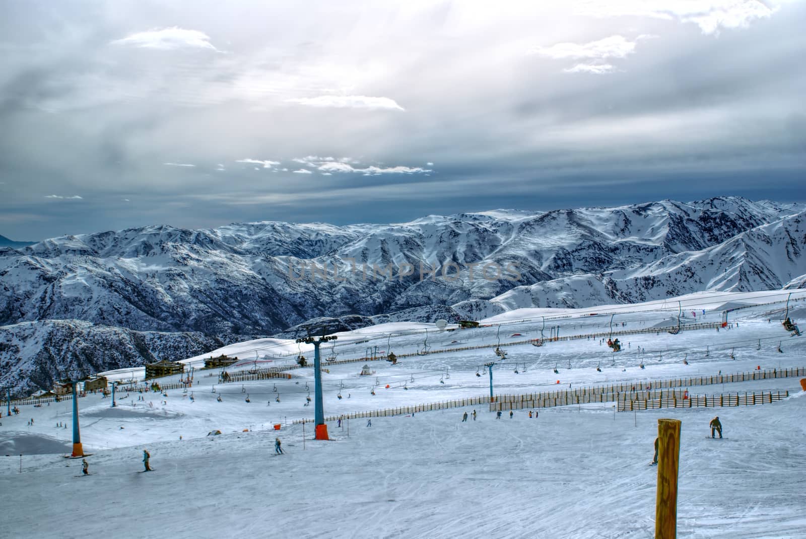 Breathtaking view of skiers and beautiful mountains at sunset in Valle Nevado