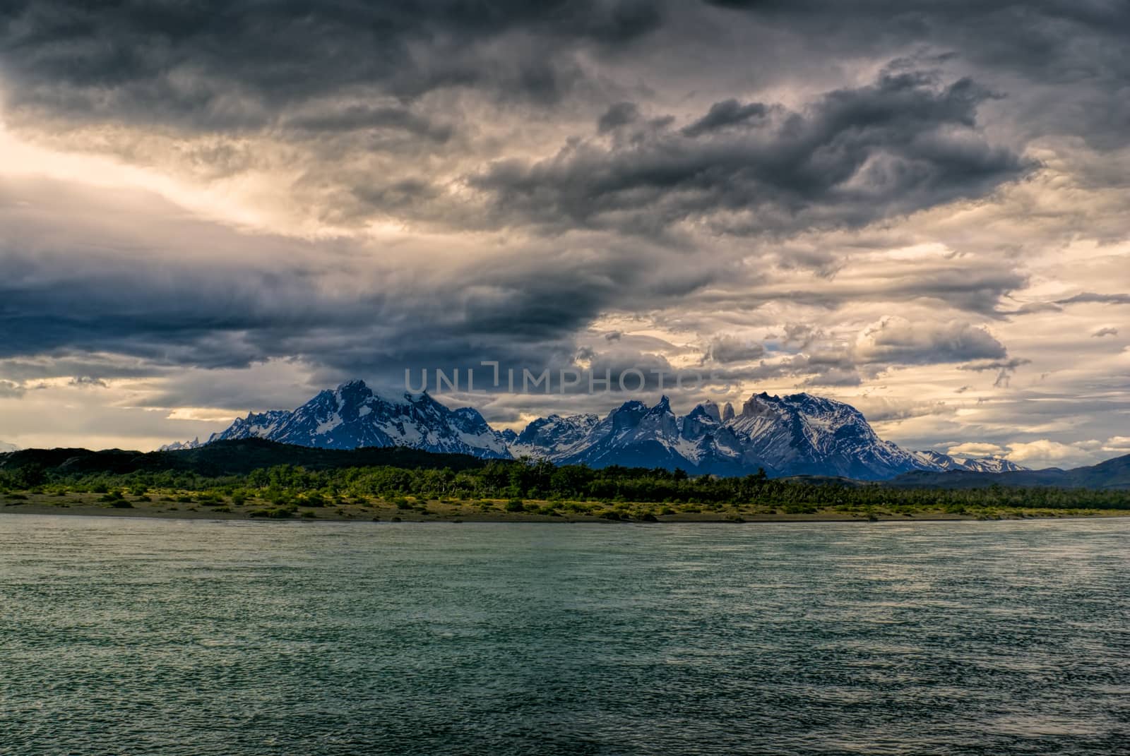 Panoramic view of a peaceful lake surface under grey sky in Torres del Paine National Park