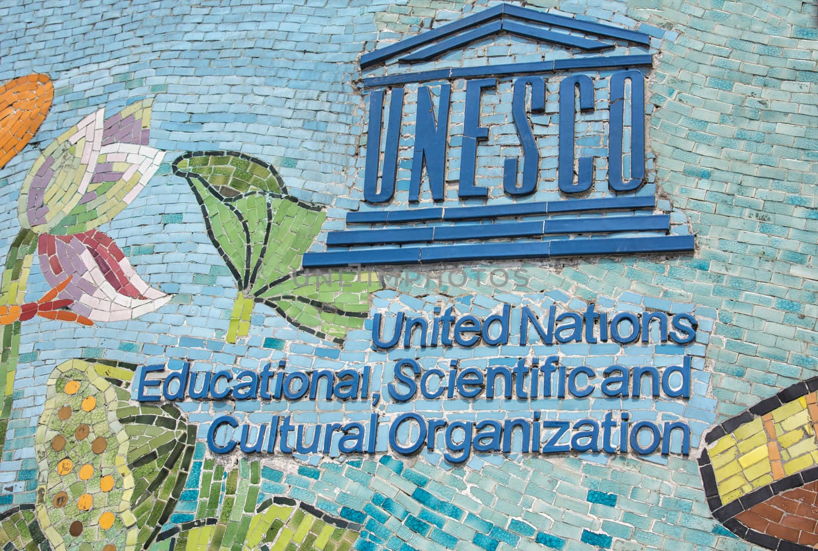 HANOI, VIETNAM - CIRCA MARCH 2012: UNESCO logo on longest mosaic wall in the world. Blue logo and name on colorful fresco.