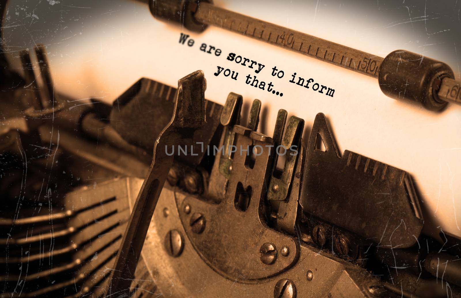 Close-up of an old typewriter with paper, selective focus, we are sorry to inform you that