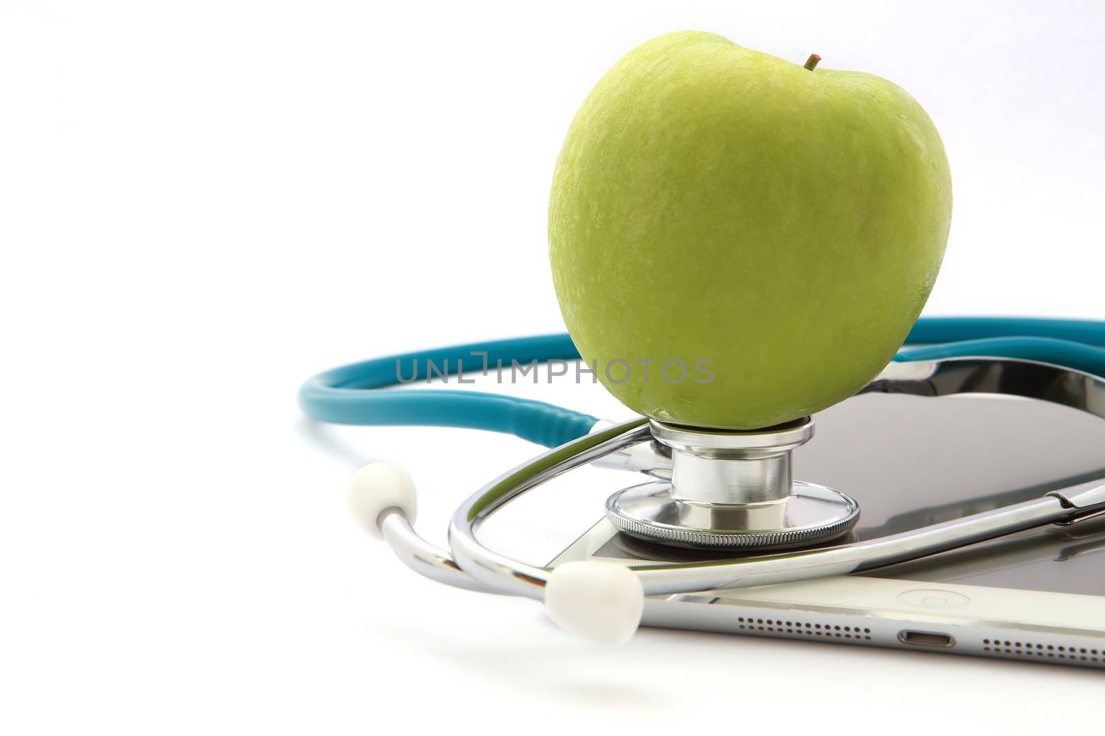 Stethoscope and green apple isolated on Tablet
