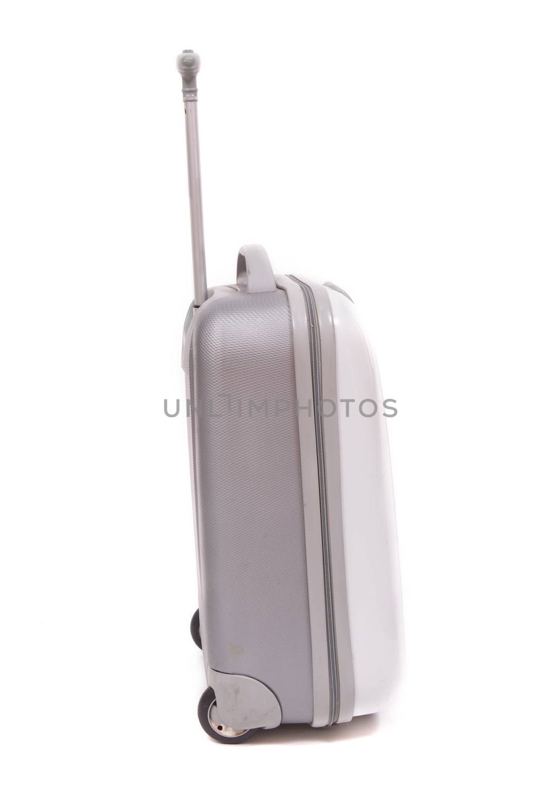 Side view of silver travel suitcase standing over white background