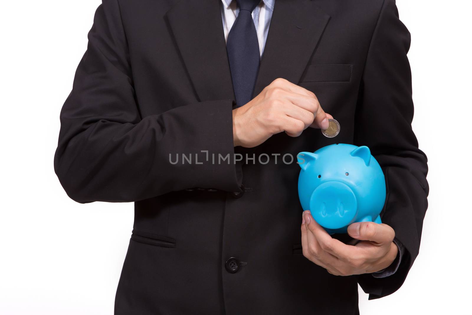 Closeup of businessman in a suit standing holding a blue piggy bank
