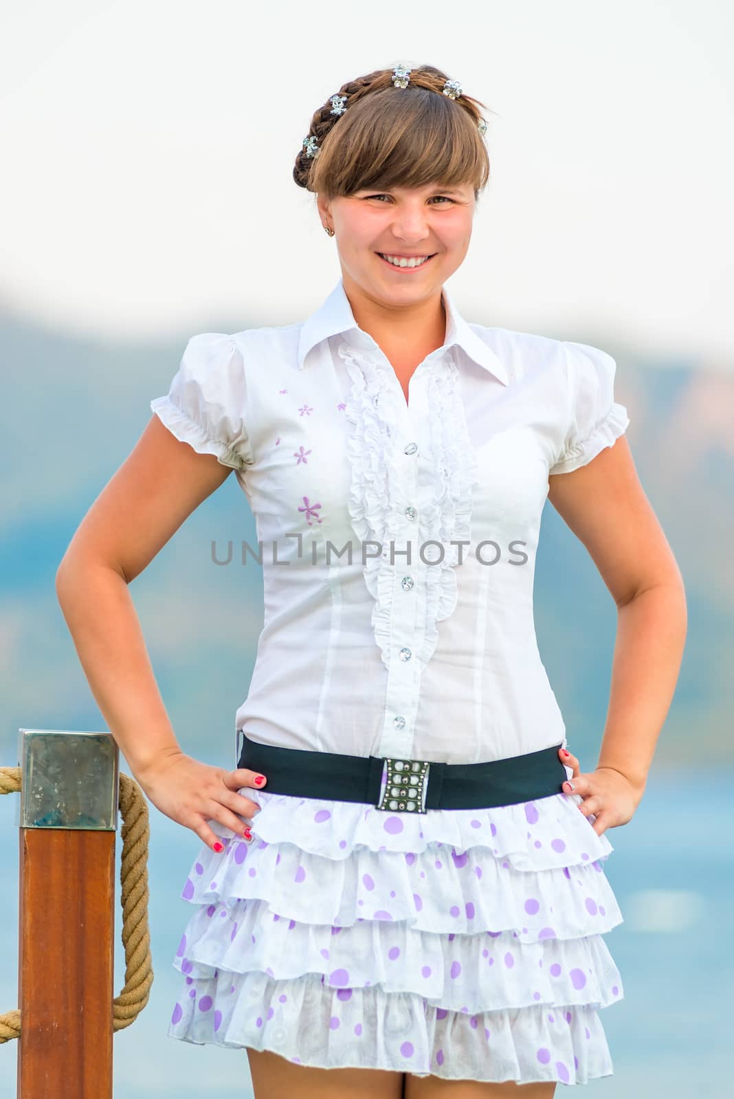 playful young girl in a white dress on the pier