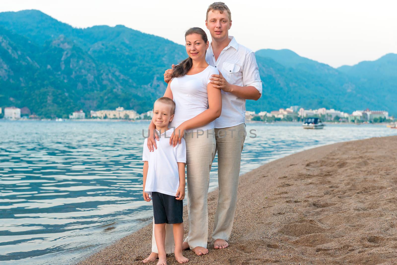 young family with son on the beach on vacation by kosmsos111