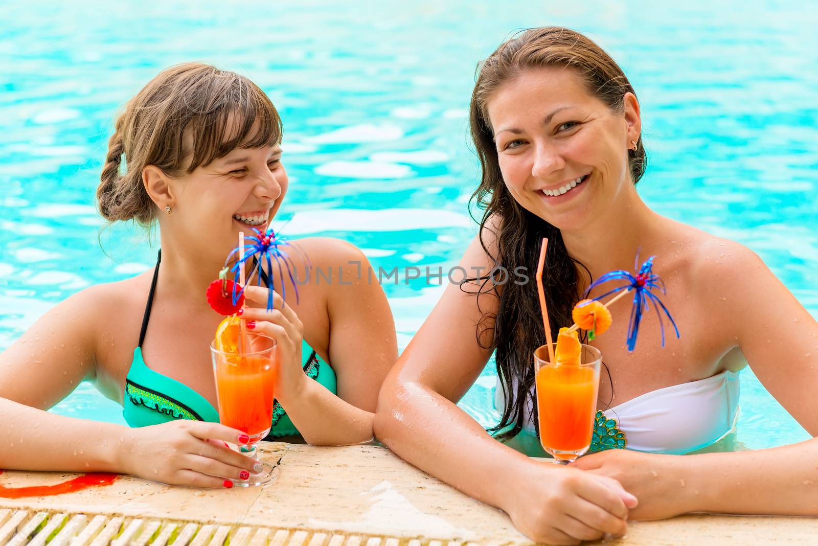 girlfriends in the pool drinking cocktails