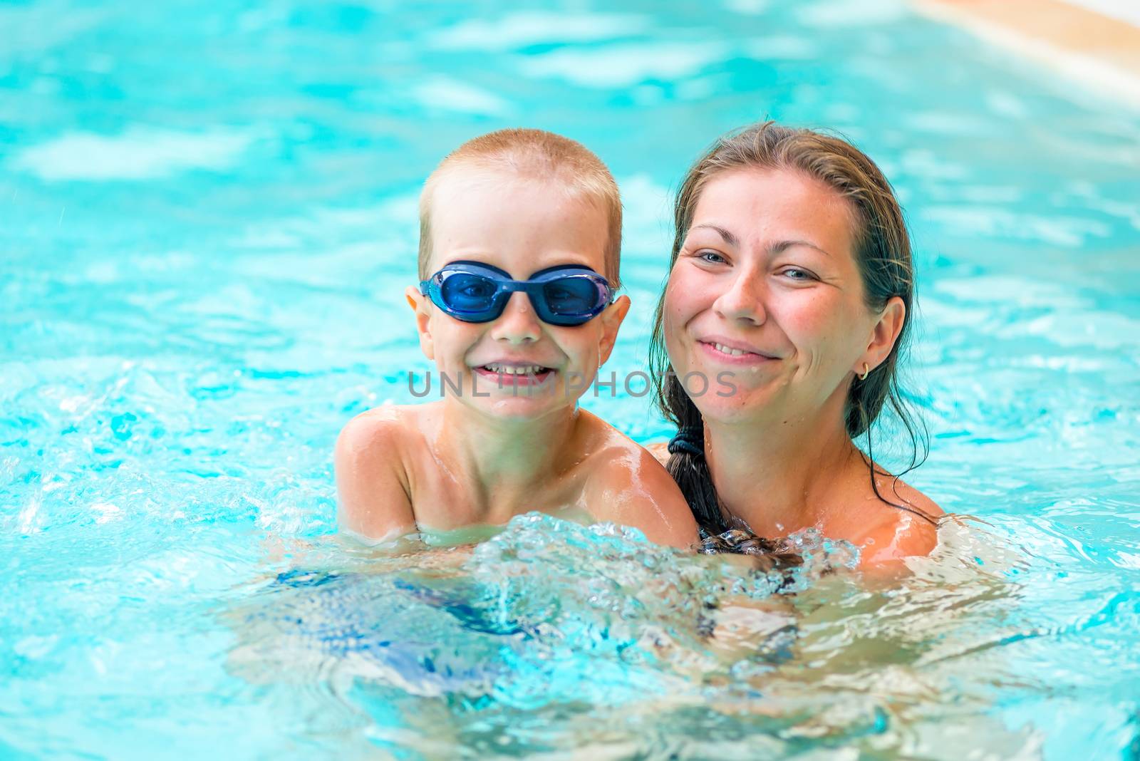 woman with her son in the pool swimming