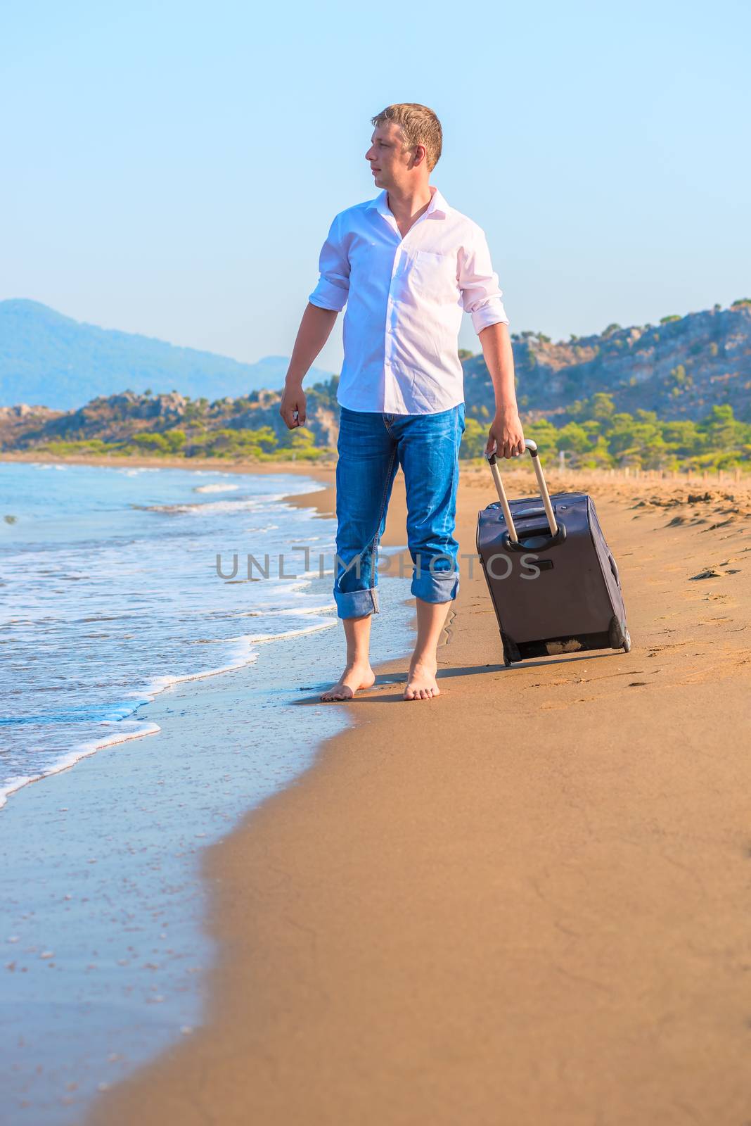 lost traveler with suitcase looking at sea