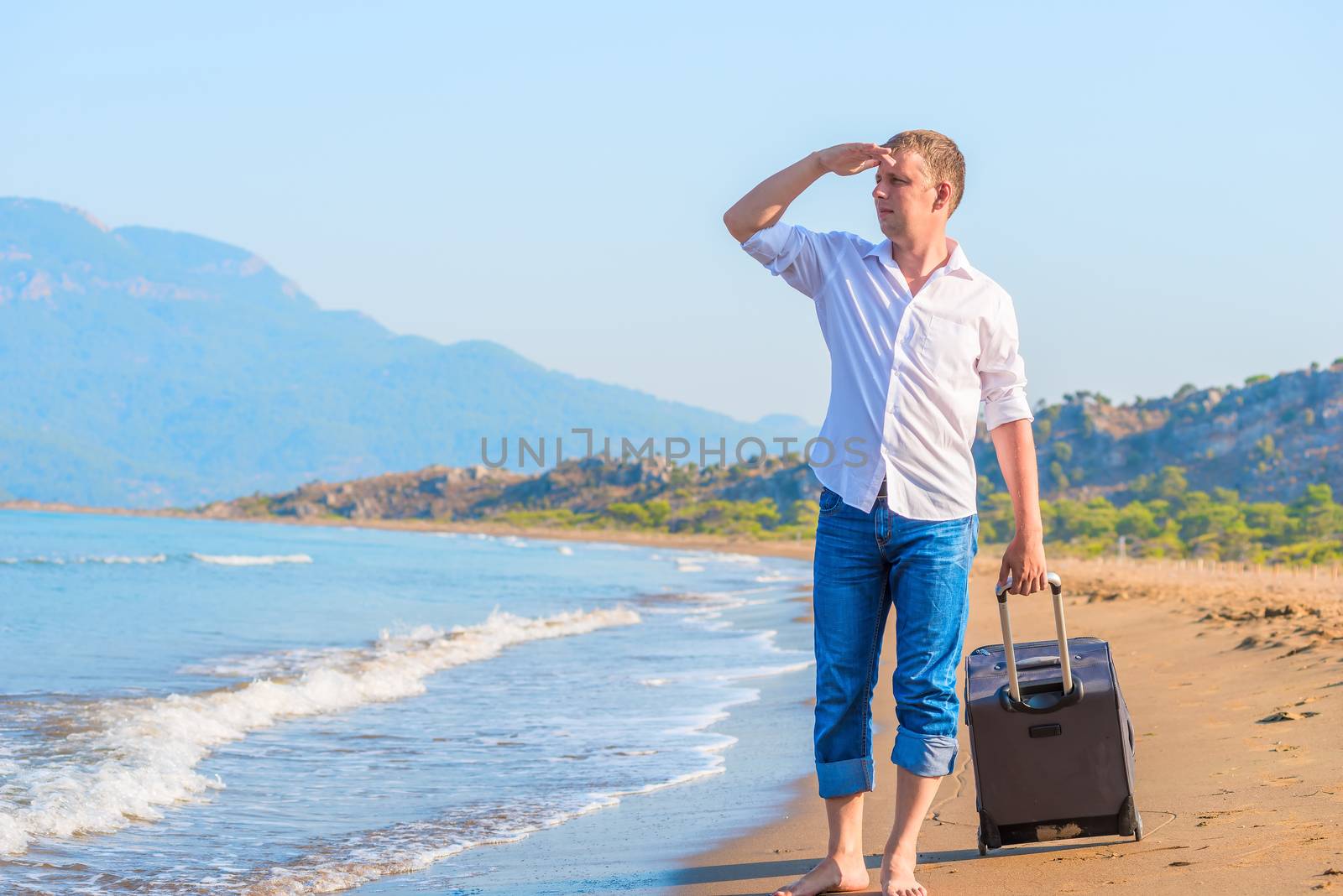 successful businessman on a desert island with a suitcase