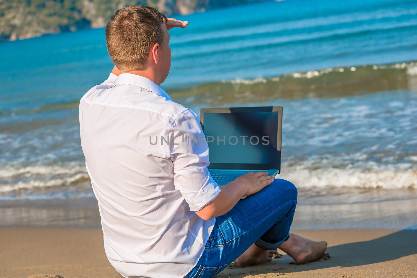 man on a desert island with a laptop looking for a ship