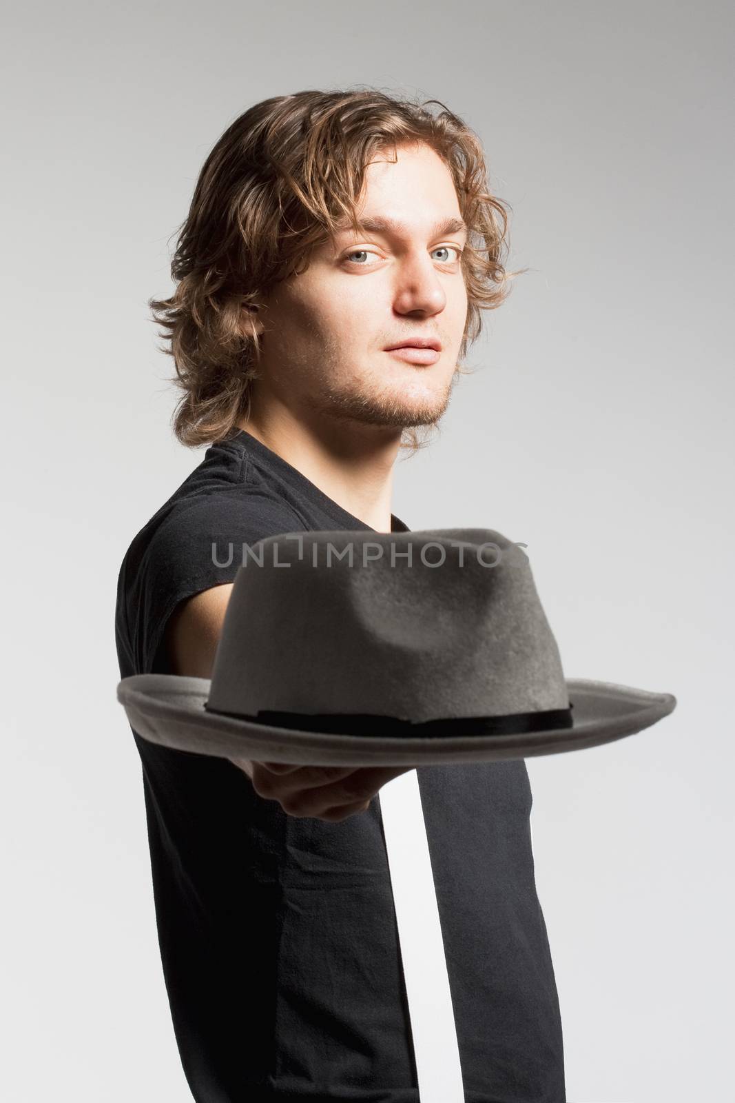 Young Man Stretching out his Arm with Hat