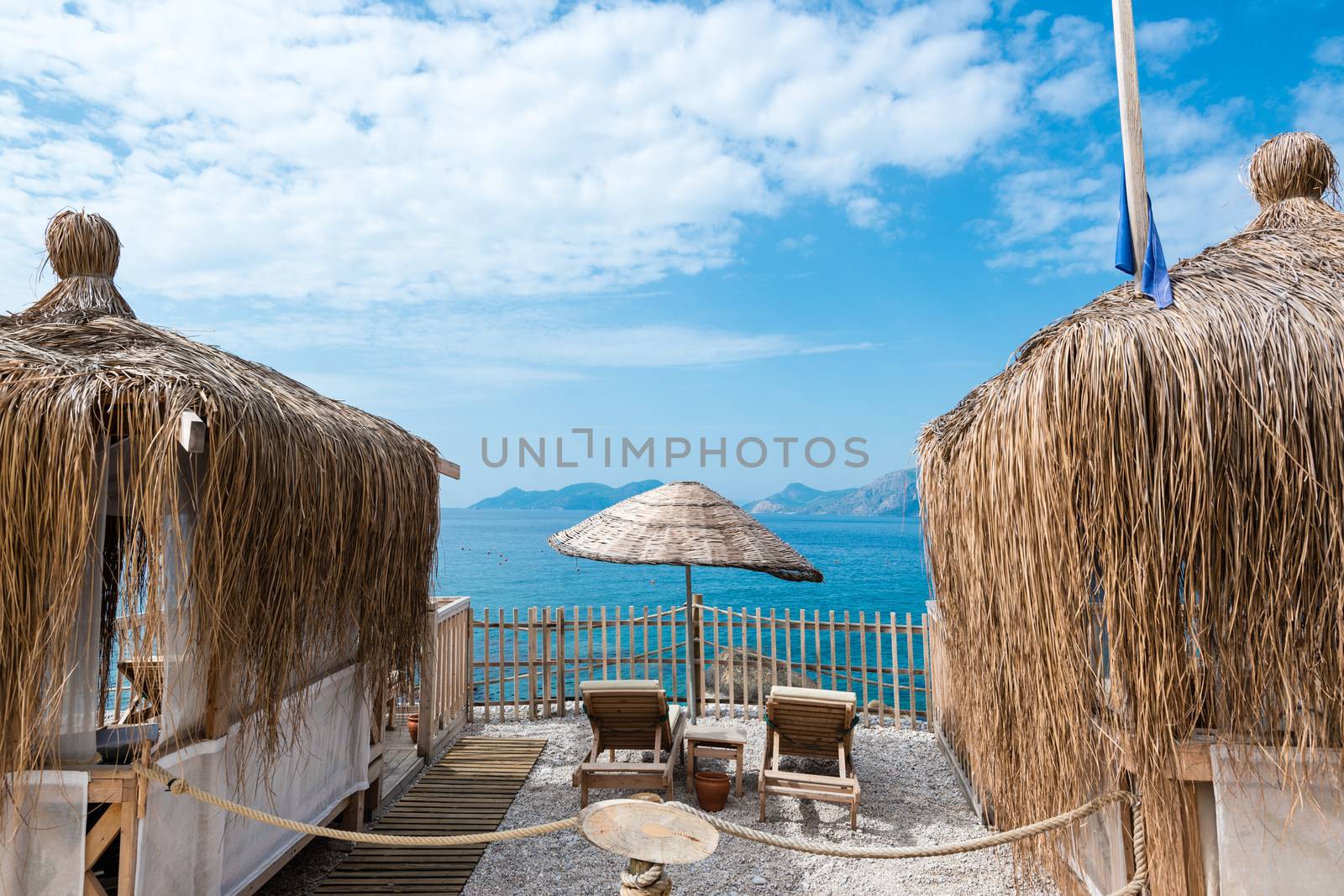 Beach huts, parasol and deck chairs in front of beautiful ocean