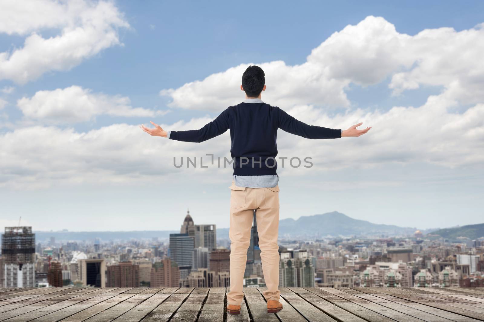 Asian man standing and looking the skyline of the city.