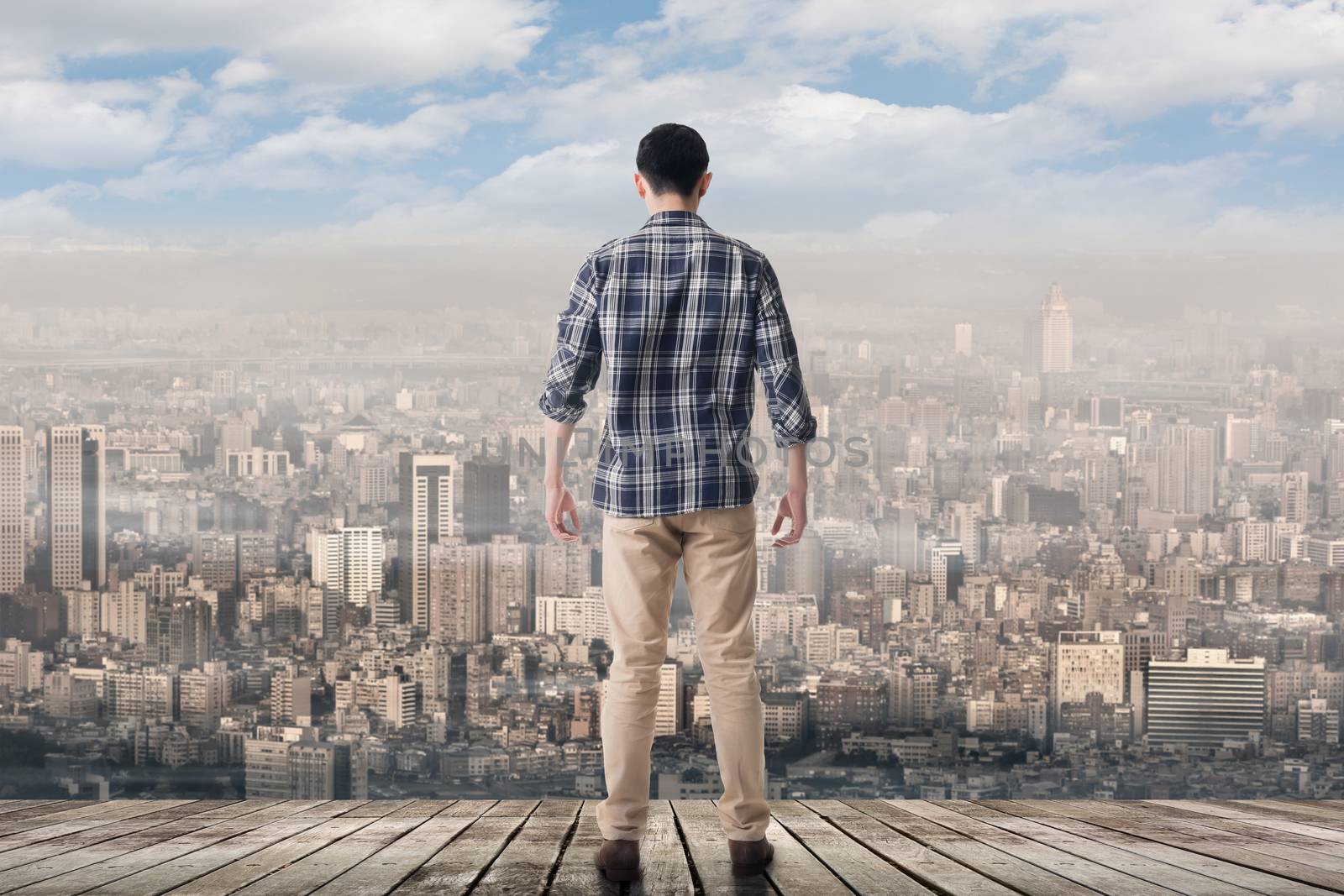 Asian man standing and looking the skyline of the city.