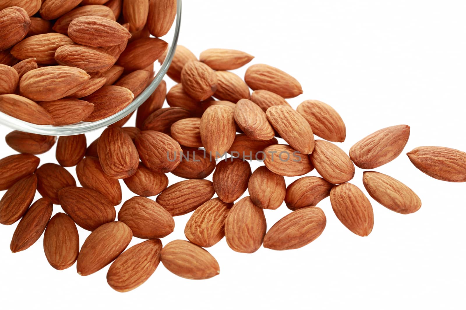 Glass bowl with almonds nuts isolated on white background.