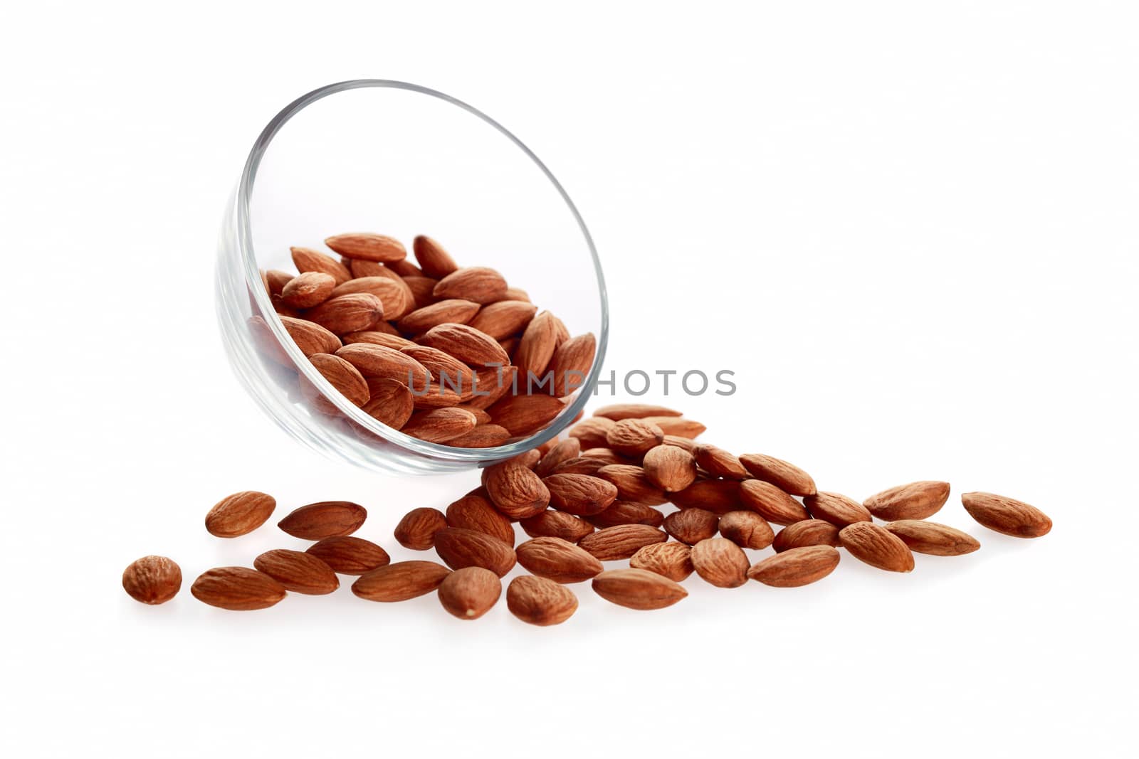 Glass bowl with almonds nuts isolated on white background.