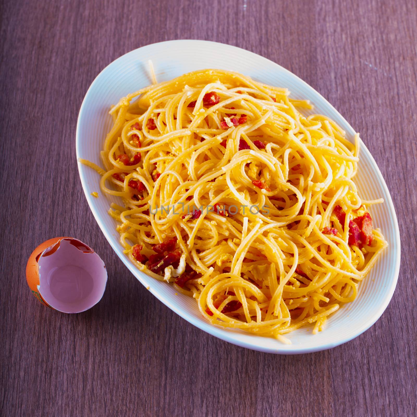 Spaghetti alla carbonara in white plate, with eggshell