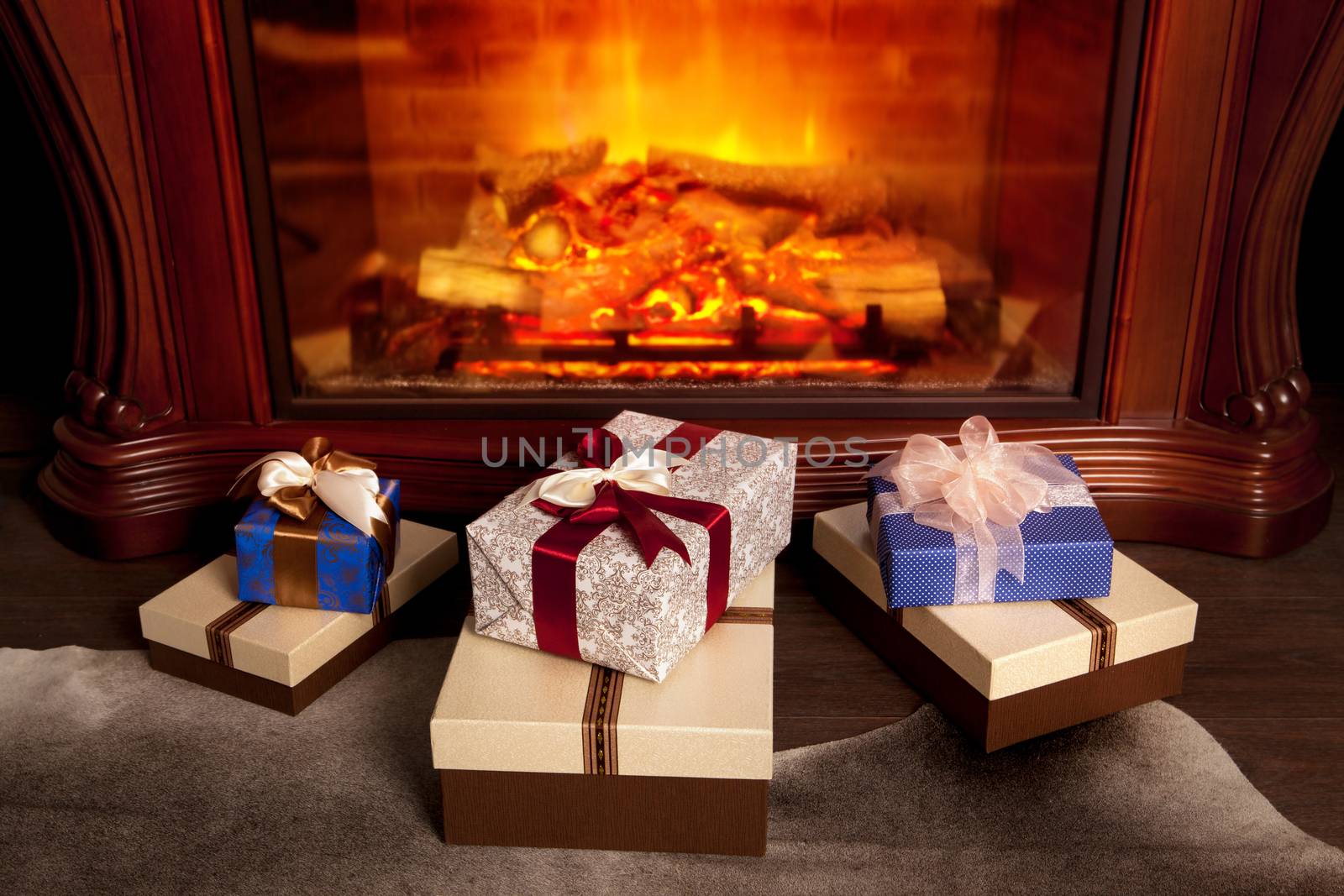 Christmas gift boxes and warm fireplace at evening