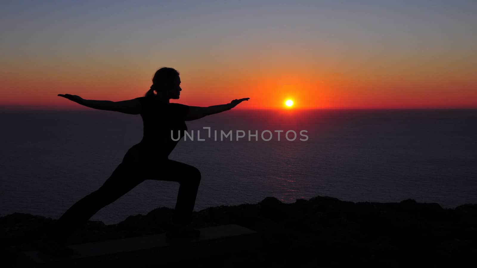 Woman doing yoga during sunset