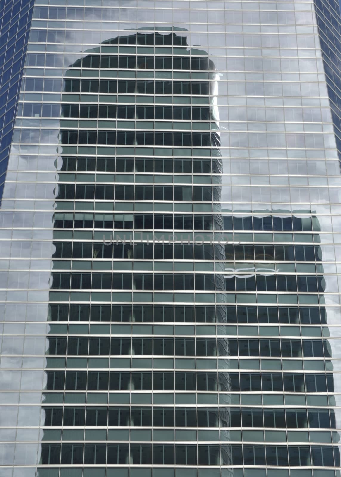 Reflection of the PwC Tower into the Crystal tower in the Four Towers Business Area, Madrid, Spain. The Crystal tower was designed by Pelli and the  PwC Tower by  Carlos Rubio Carvajal and Enrique �lvarez-Sala Walter.