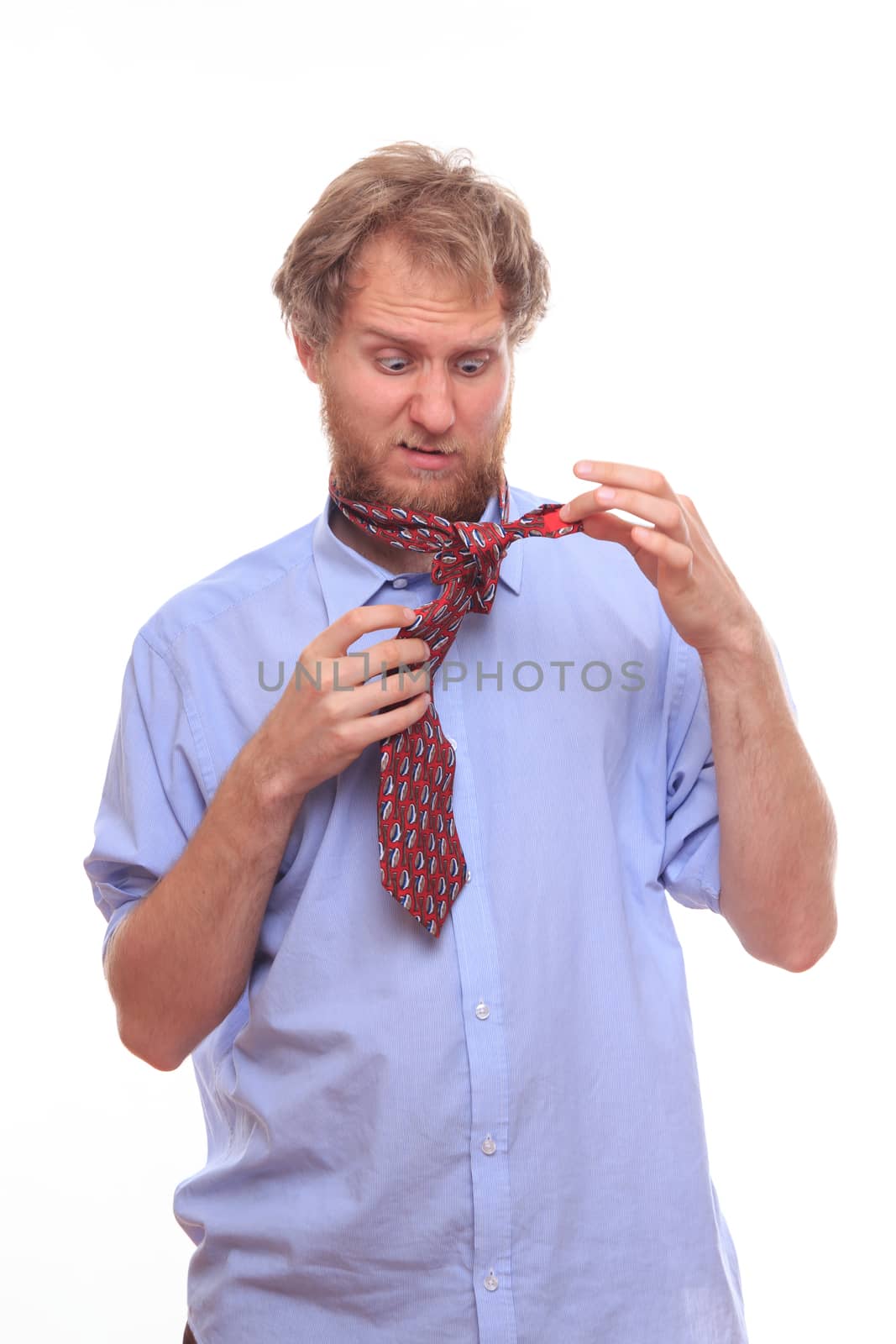 Man at morning trying to tie a tie on his neck 