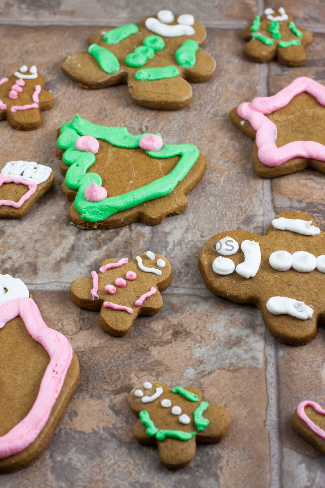Decorated Gingerbread Christmas cookies on a tile counter top.