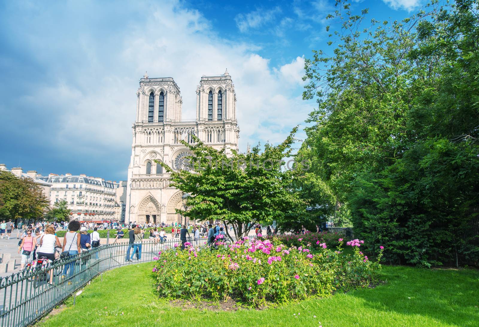 PARIS - JUNE 14, 2014: Tourists visit Notre Dame. More than 30 million people visit the city every year.